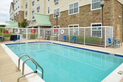 a large swimming pool with chairs and a building at TownePlace Suites Arundel Mills BWI Airport in Hanover