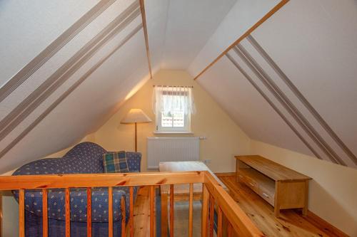 a attic room with a couch and a window at Ferienhaus Boddenhus in Middelhagen