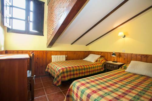 Habitación de hotel con 2 camas y ventana en Nuestra Señora del Carmen, en San Sebastián de Garabandal