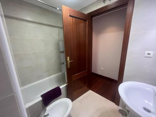 een badkamer met een wastafel, een toilet en een douche bij Preciosa casa con jardín in Boó de Piélagos