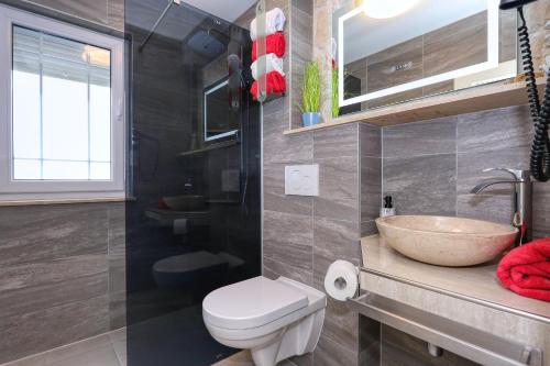 a bathroom with a sink and a toilet and a bowl at Appartement 3 Zaton beach modern und stilvoll eingerichtet in Strandnähe in Zaton