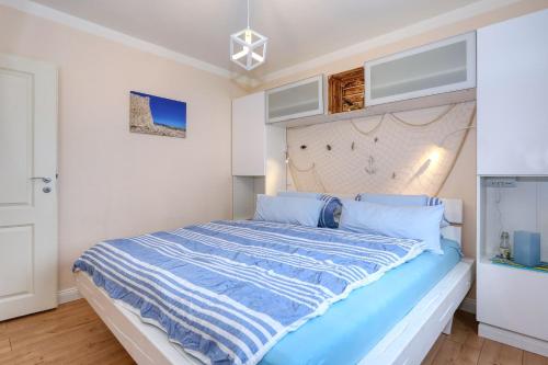 a bedroom with a large bed with blue sheets at Appartement 3 Zaton beach modern und stilvoll eingerichtet in Strandnähe in Zaton