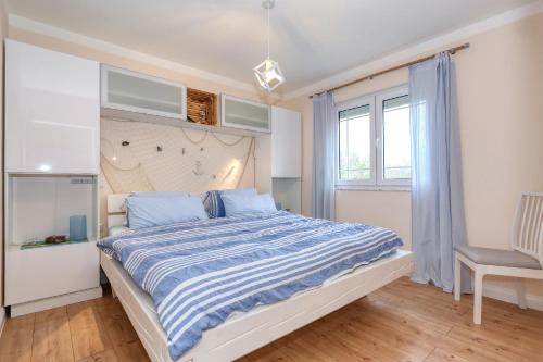 a bedroom with a large bed and a chair at Zaton beach Appartement 3 modern und stilvoll eingerichtet in Strandnähe in Zaton