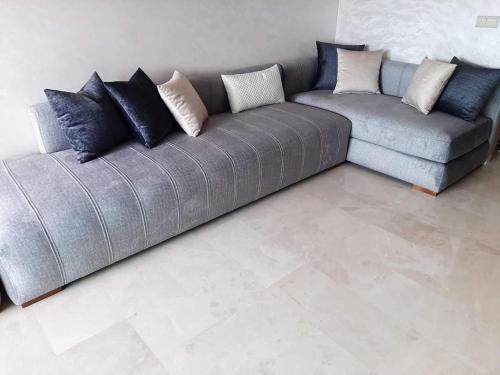 a couch with pillows on it in a living room at Sweet Room Airport 5 in Deroua