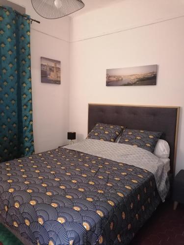 une chambre avec un lit avec une couette bleue dans l'établissement Plage des Catalans, à Marseille