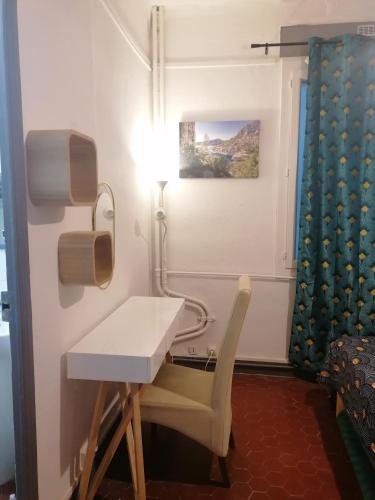 une pièce avec une table, une chaise et un bureau dans l'établissement Plage des Catalans, à Marseille