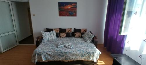 a bed in a bedroom with purple curtains at Apartament Nina in Mangalia