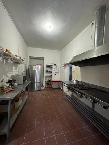 a large kitchen with a large stove and refrigerator at Hostal Bustamante in Bustamante