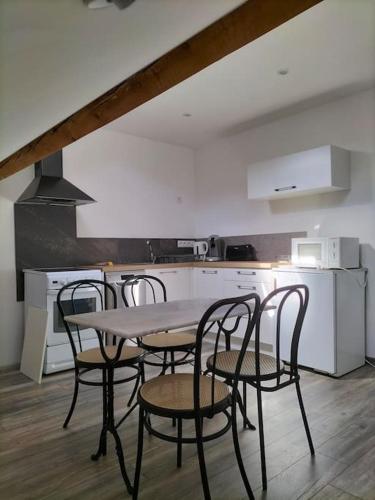 une cuisine avec une table et des chaises dans une cuisine dans l'établissement Appartement pour 4prs dans maison individuelle, à Allemont