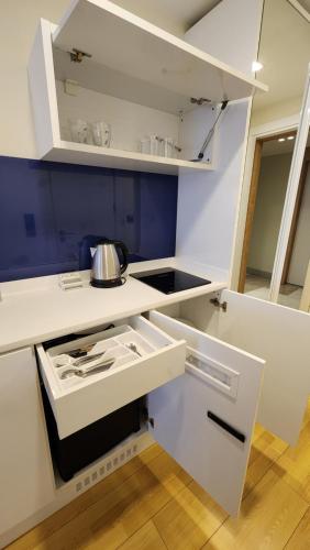 uma cozinha com armários brancos e uma panela no fogão em Sea Breeze Studio, Orbi City, block A em Batumi