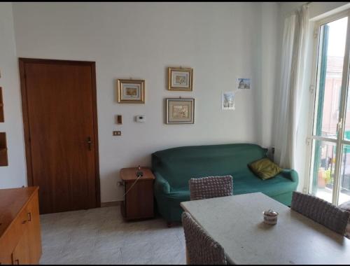 uma sala de estar com um sofá verde e uma mesa em 1 Room(2 Beds)Messina, Ganzirri em Messina