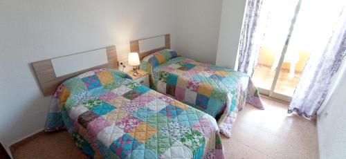 1 dormitorio con 2 camas individuales y ventana en Apartamento Frente al club Nautico, soleado y en primera linea de playa, en Villajoyosa