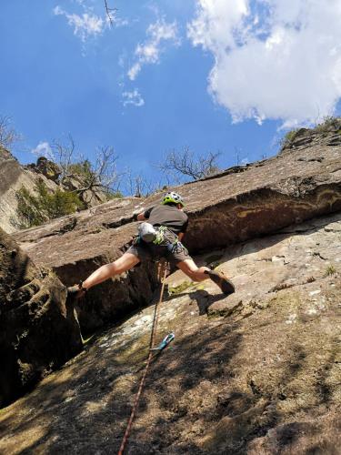 a man climbing up a rock with a rope at Relax sul Brembo - Casa Vacanze in Olmo al Brembo