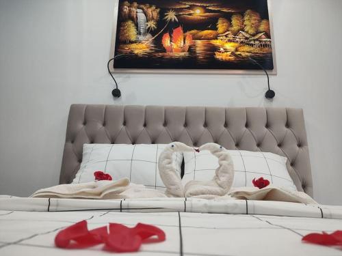 2 cygnes blancs posés sur un lit avec des fleurs rouges dans l'établissement Apartment in the Center of Athens, à Athènes
