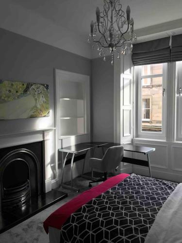 um quarto com uma cama, uma mesa e uma lareira em Grange Lone entire apartment with two double beds em Edimburgo