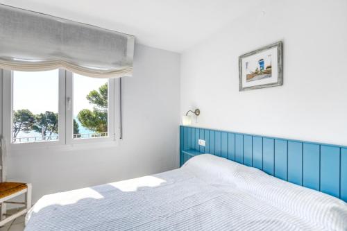 カレリャ・デ・パラフルジェリにあるApartament Alegríaのベッドルーム(青と白のベッド1台、窓付)