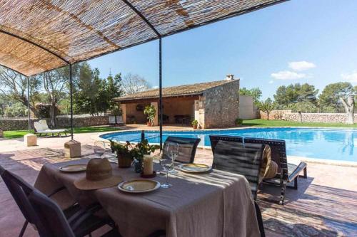 a dining table and chairs next to a swimming pool at Finca Cas Contador Mallorca in Algaida