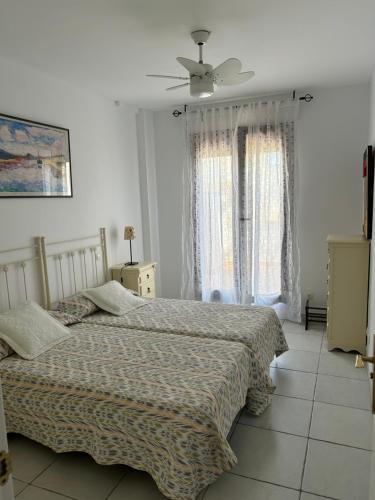 1 Schlafzimmer mit 2 Betten und einem Deckenventilator in der Unterkunft Tranquilidad Sol Playa y Naturaleza in Vera