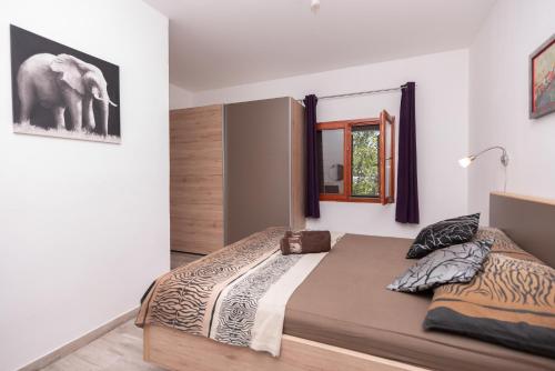 1 dormitorio con 1 cama grande y espejo en Villa Lino, en Dugopolje