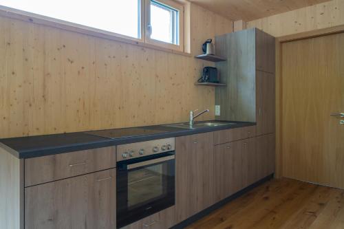a kitchen with a sink and a stove at Bergreich Appartement 1 in Schoppernau