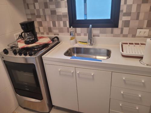 uma cozinha com um lavatório e um fogão em Apartamento novíssimo Copacabana no Rio de Janeiro