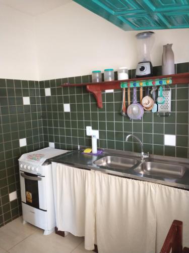 a kitchen with a sink and a stove at Vila Beija-flor in Canoa Quebrada