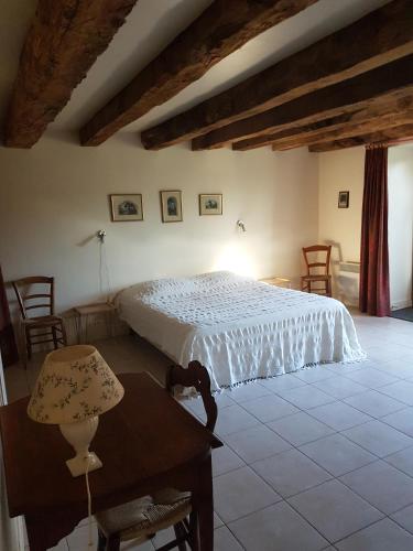 une chambre avec un lit, une table et des chaises dans l'établissement Gite de France Rosalie, à Bannes
