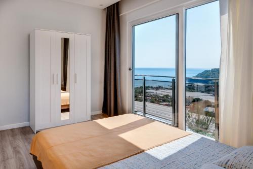 a bedroom with a bed and a large window at Begonvilla Apart Karaöz in Antalya
