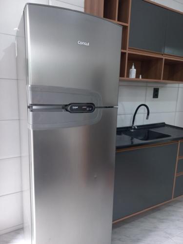 una nevera de acero inoxidable en una cocina en Apartamento Superior, en Balneário Camboriú