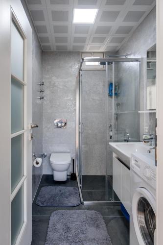 a bathroom with a shower and a toilet and a sink at Begonvilla Homes Karaöz in Karaoz