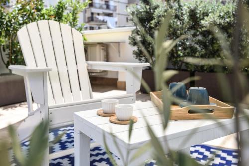 two white chairs and a table with cups on it at Maison Chene con vasca idromassaggio in Bisceglie