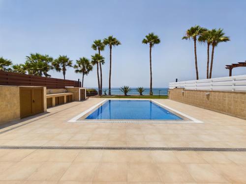 a swimming pool with a view of the ocean at Amazing frontline beach villa in Larnaca