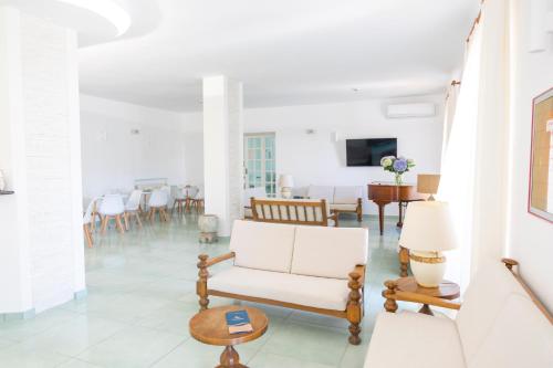 sala de estar con sofá blanco y sillas en Hotel La Luna en Ischia