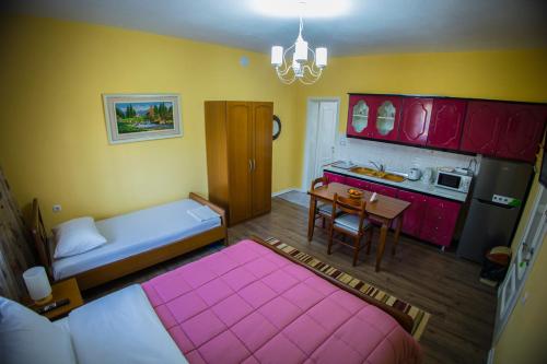Cette petite chambre comprend un lit rose et une cuisine. dans l'établissement Vila Visi Hotel, à Korçë