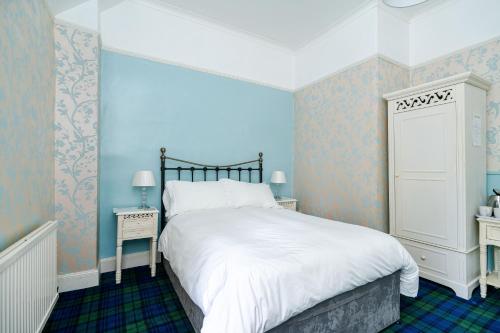 a bedroom with a large bed with blue walls at Mansewood Country House in Lochearnhead