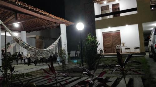 a house with a hammock in a courtyard at night at Casarão na Praia de Camboinha a 250 metros do mar in Cabedelo