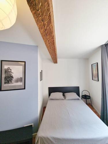 une chambre avec un grand lit dans une pièce dans l'établissement Studio proche Capitole - Terrasse - Wifi - TV, à Toulouse