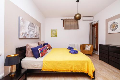 a bedroom with a bed with a yellow blanket at Finca Sa Fuente in Felanitx