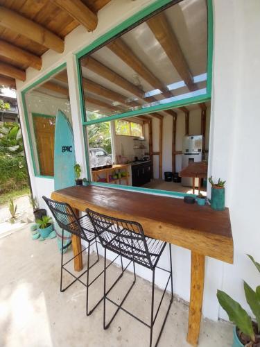 a large wooden table with two chairs in front of a house at Flor de bambú in Uvita