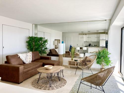 un salon avec un canapé, une table et des chaises dans l'établissement Grand Duplex climatisé avec terrasse face à la mer, à Sainte-Maxime