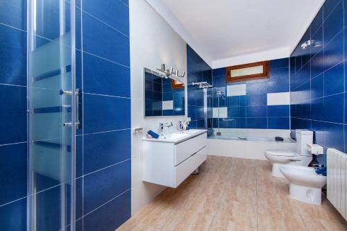a blue bathroom with two toilets and a sink at Finca Sa Fuente in Felanitx
