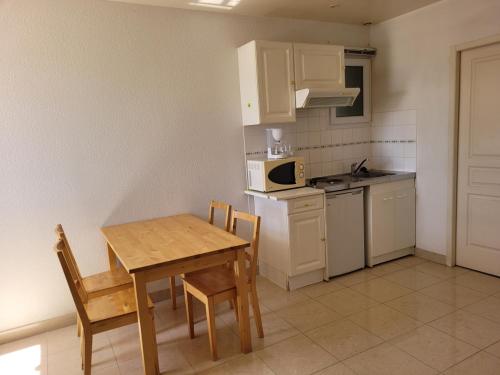 - une cuisine avec une table et des chaises en bois ainsi qu'une cuisinière dans l'établissement Villa Cesaria, à Loupian