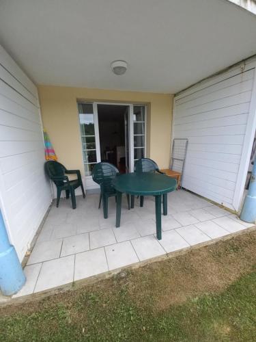 d'une terrasse avec une table et des chaises vertes. dans l'établissement appartement au bord du lac, à Marciac