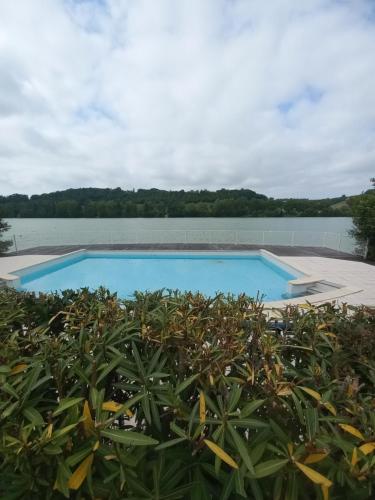 une piscine avec un lac en arrière-plan dans l'établissement appartement au bord du lac, à Marciac