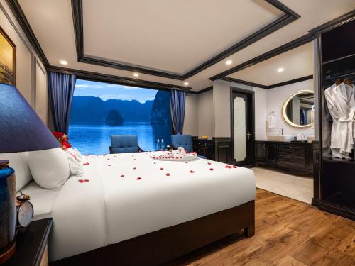 a bedroom with a large white bed with a large window at M'Gloria Cruise in Ha Long