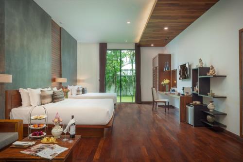 um quarto com uma cama e uma mesa num quarto em Shintana Saya Residence em Siem Reap