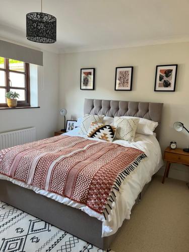 a bedroom with a large bed with a red and white comforter at Wharf Cottage in Coalbrookdale