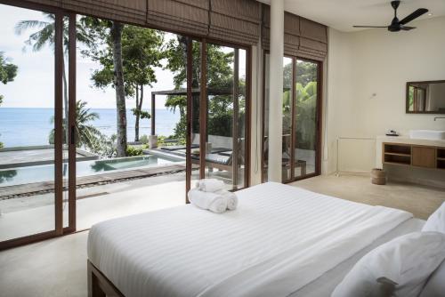 a bedroom with a bed with a view of the ocean at Nest Sense Resort in Ko Chang
