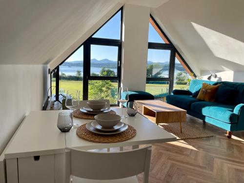 een woonkamer met een tafel en een blauwe bank bij Còsagach Flat near Oban in Barcaldine