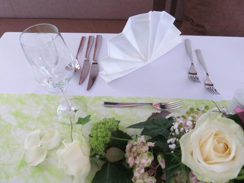 a table with a wine glass and flowers on it at Hotel Loy in Gröbming